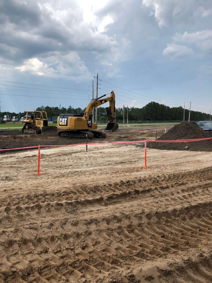 A construction site with two large trucks and one big truck.