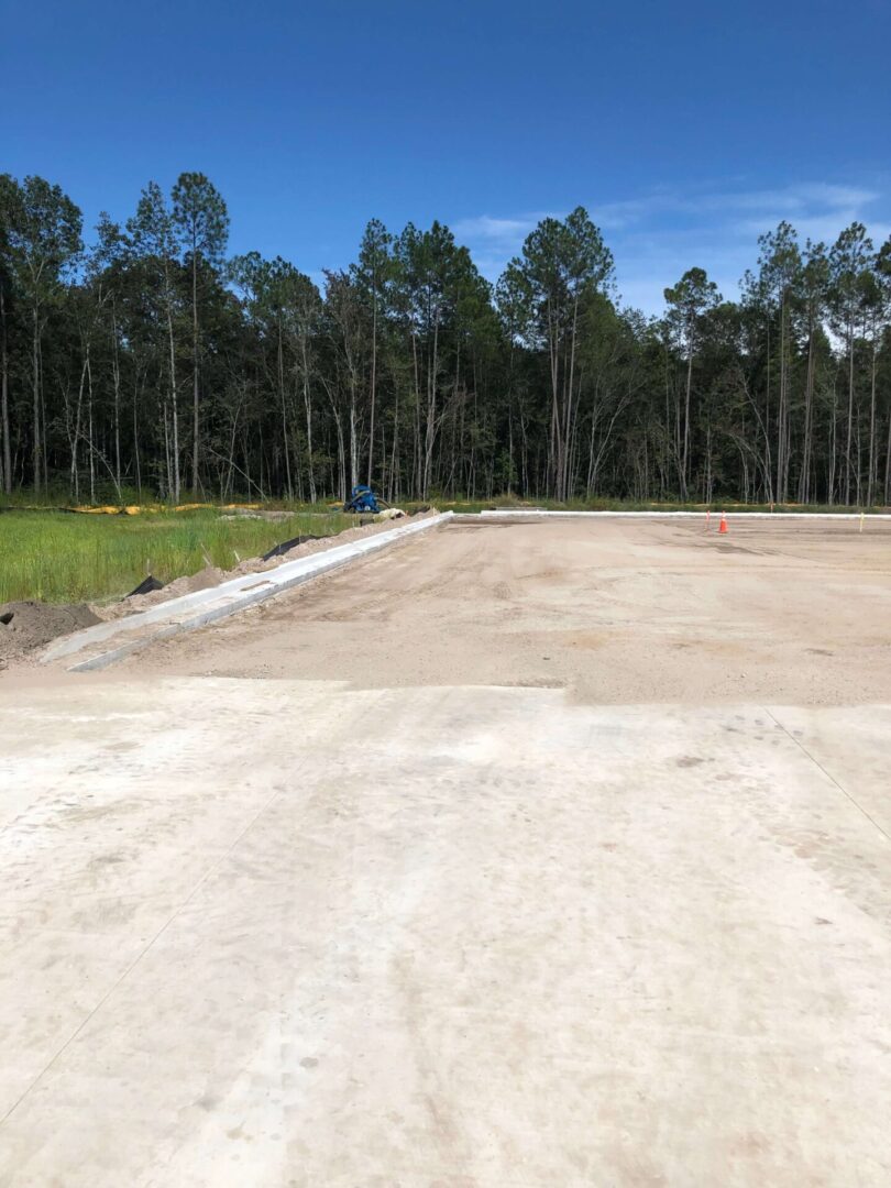 A dirt road with trees in the background