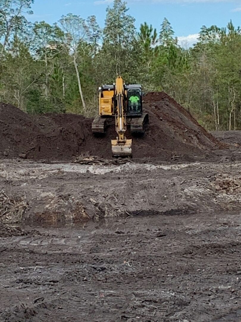 A yellow and black tractor is in the dirt